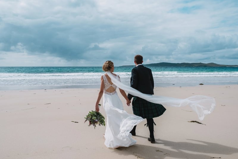 bride and groom hand in hand at a beach wedding in Scotland