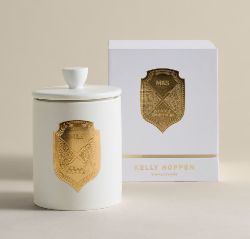a white and gold decorative candle with lid.
