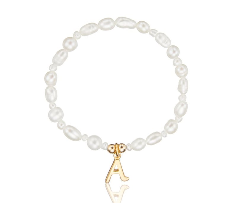 a child's pearl bracelet with gold A initial