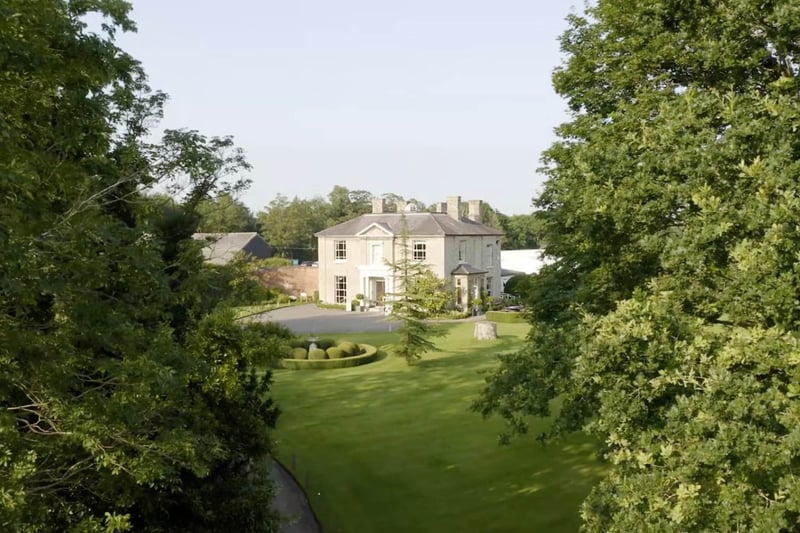 Fennes exclusive-use wedding venue exterior, Georgian manor house viewed through parkland trees, Essex