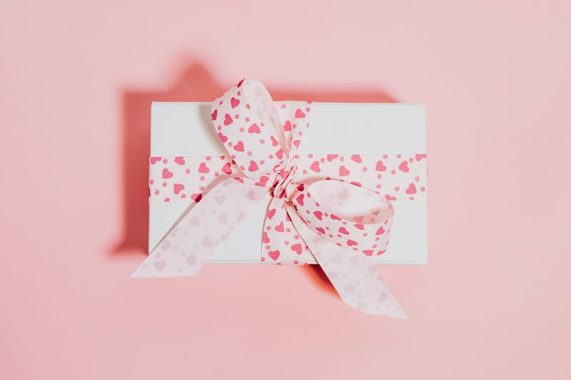 a pink and white wrapped wedding gift.