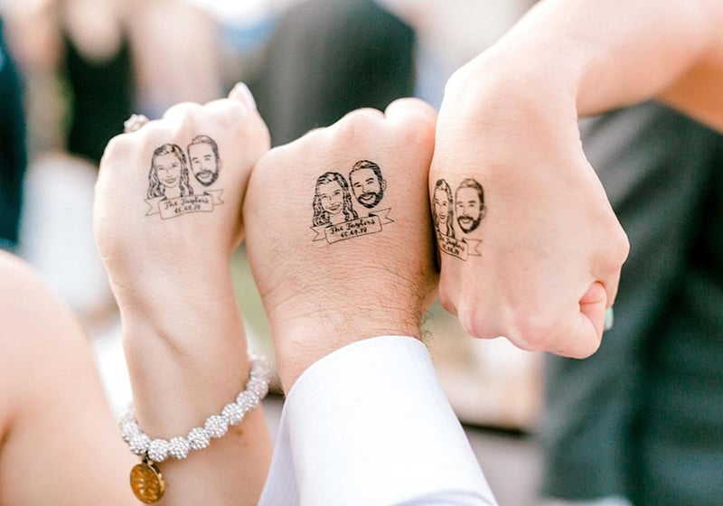 guest hands showing customised tattoos of the newlyweds' faces.