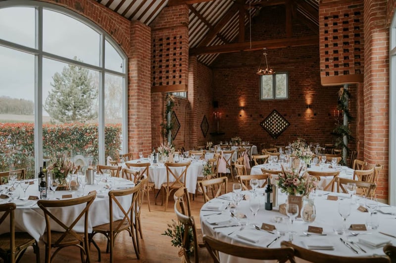 Swallows Nest Barn exclusive-use wedding venue, brick reception room with round tables, Warwickshire