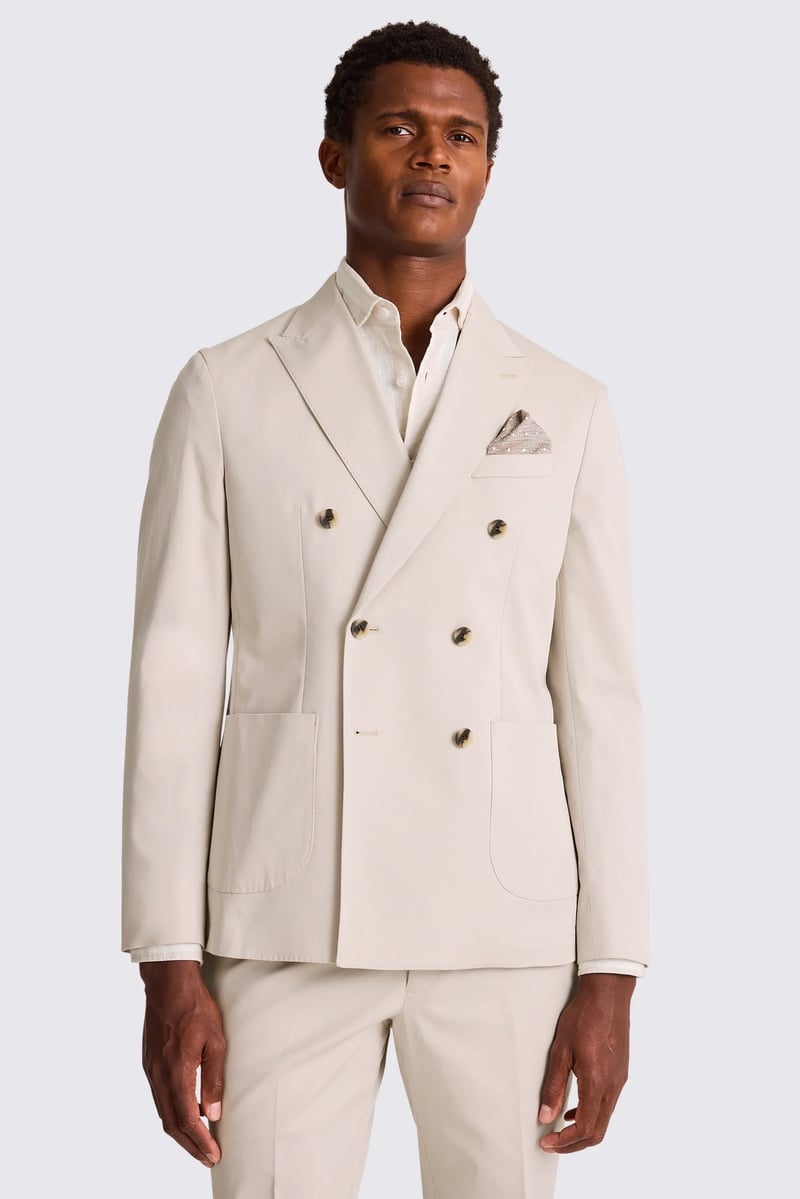 a male model wears a cream coloured double-breasted cotton suit.