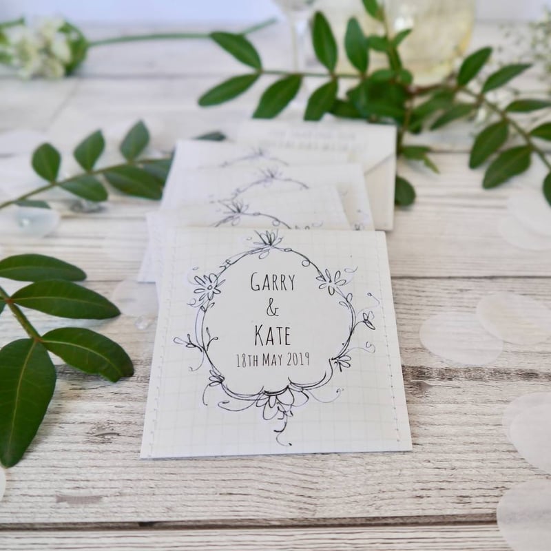 personalised tea bag packets on a wooden table with foliage.
