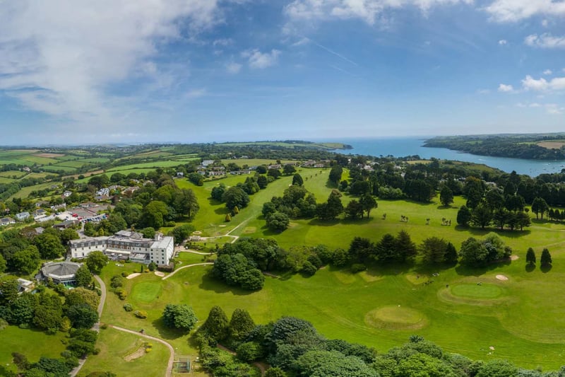 Aerial view of a five star hotel beach wedding venue surrounded by green fields with the sea to the left