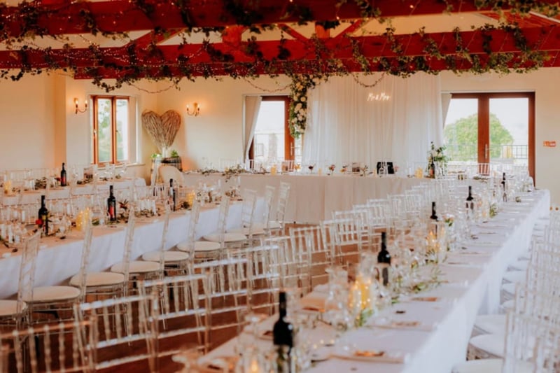 Italian-villa style wedding reception with terracotta floors and clear chiavari chairs