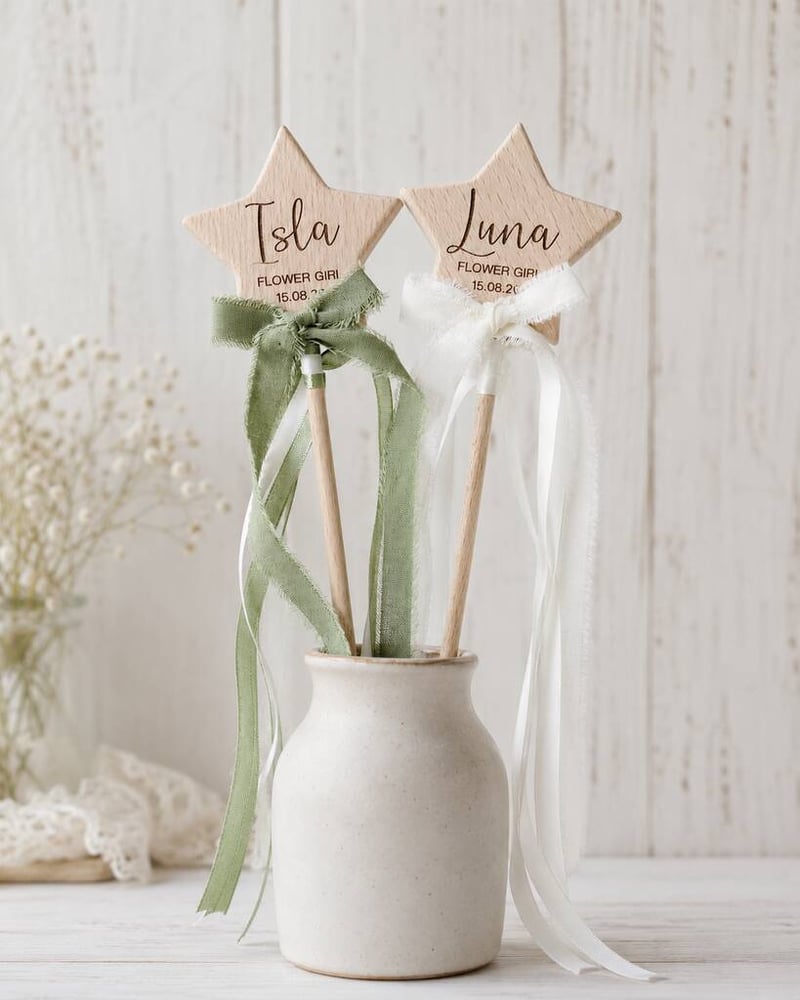 two wooden flower girl wands with ribbons in a white vase