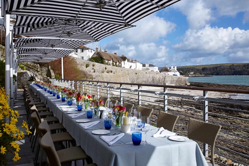 A long banquet style wedding table set up over looking the beach at Hotel Tresanton