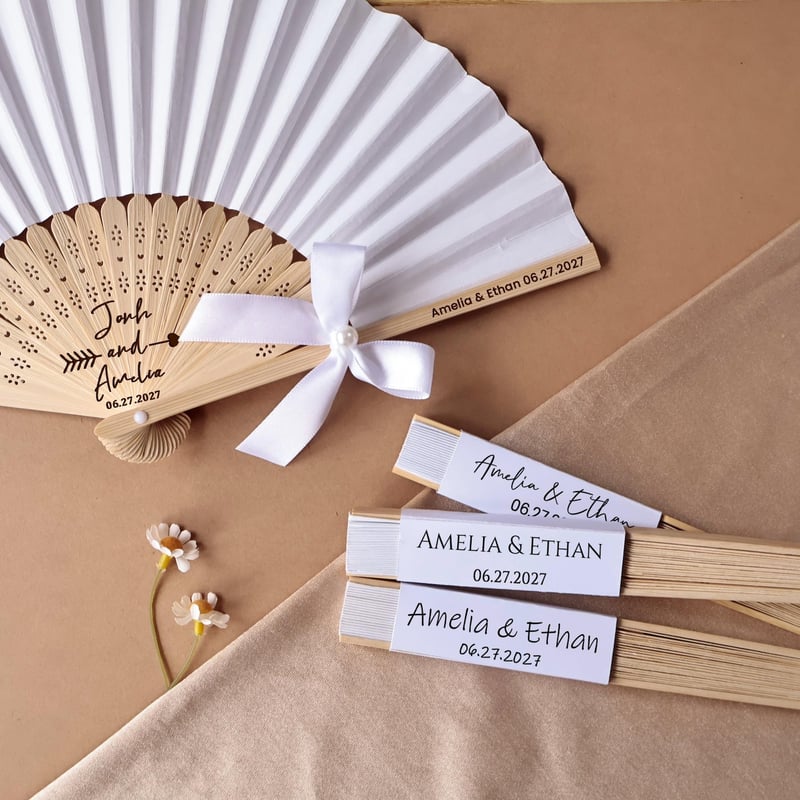 white and wood fans customised with the wedding couple names and wedding date.