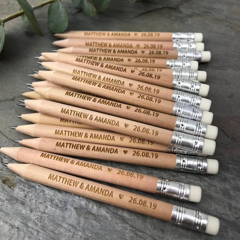 a pile of miniature personalised pencils engraved with names.
