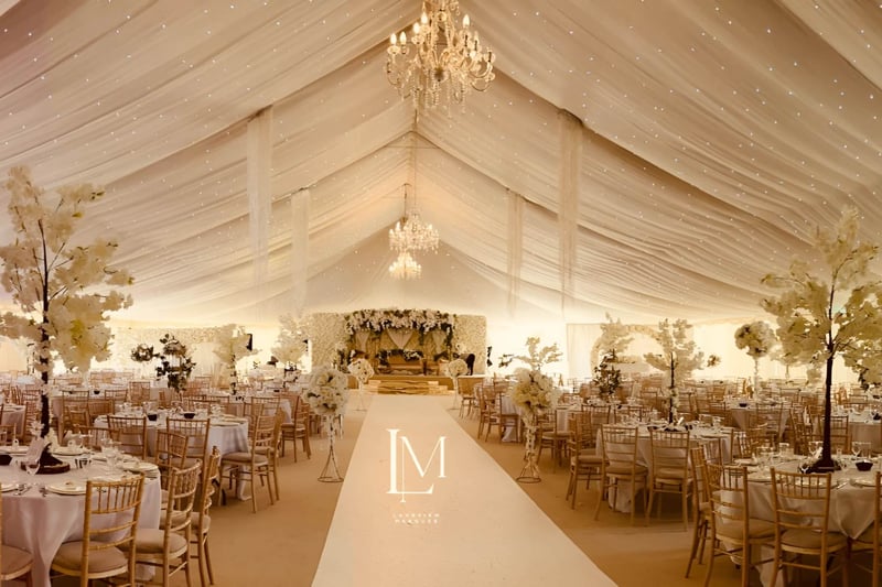 Grand marquee wedding venue with chandeliers and trees for an asian wedding