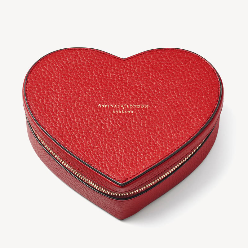 a red leather heart-shaped jewellery case embossed with gold type.