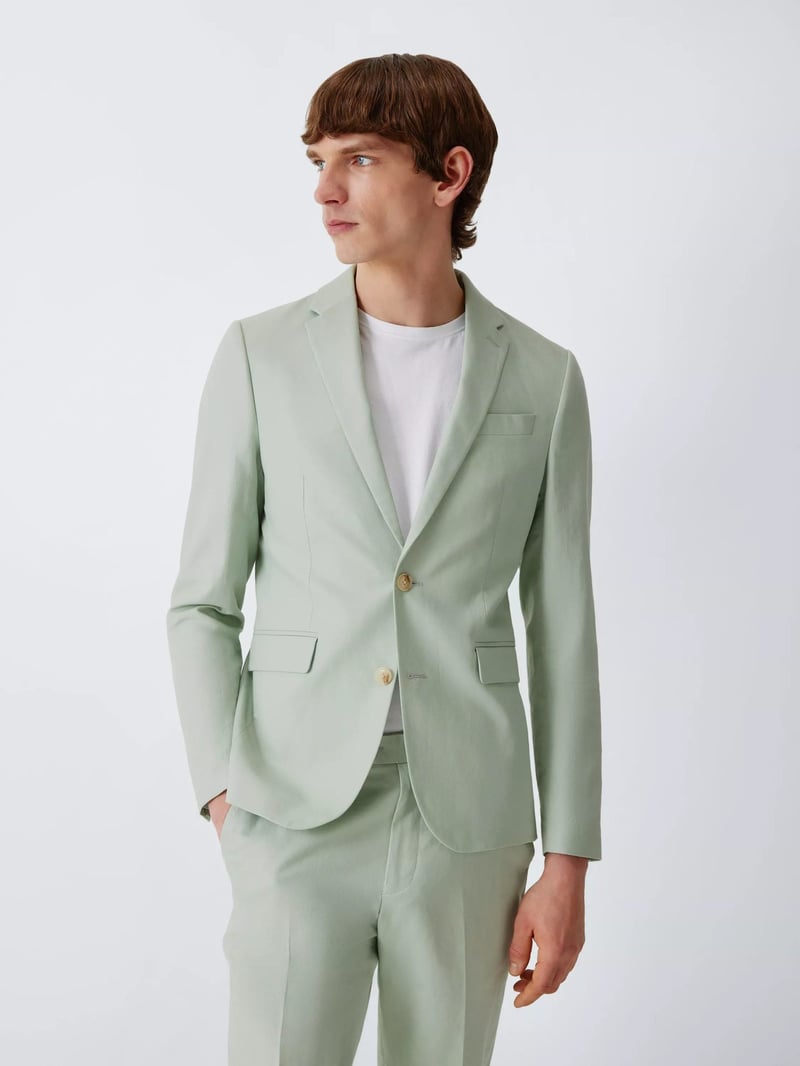 a male model wearing a slim-fit mint coloured suit with white t-shirt.
