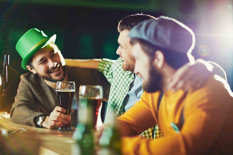 three men drinking in a bar and smiling.