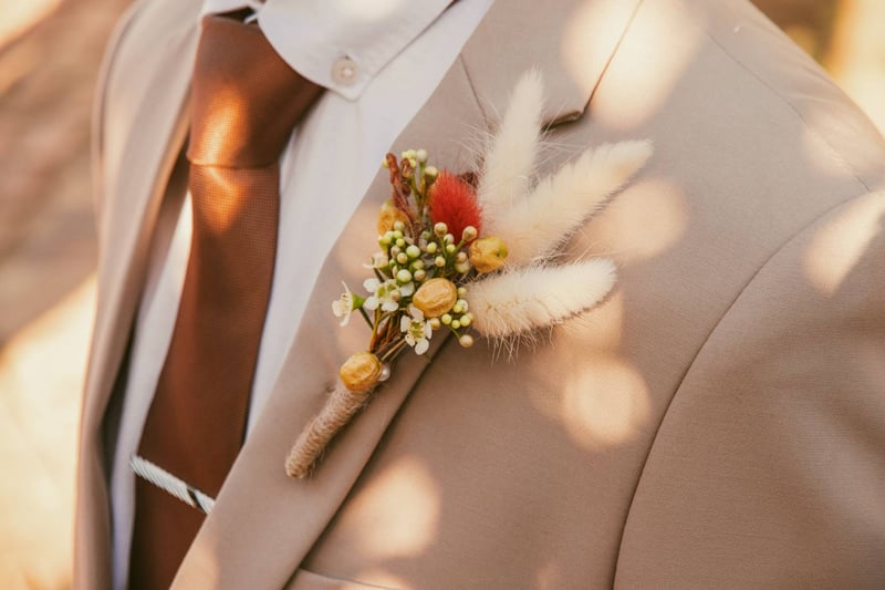 Close-up of a stylish wedding boutonniere on a tan suit jacket, perfect for grooms