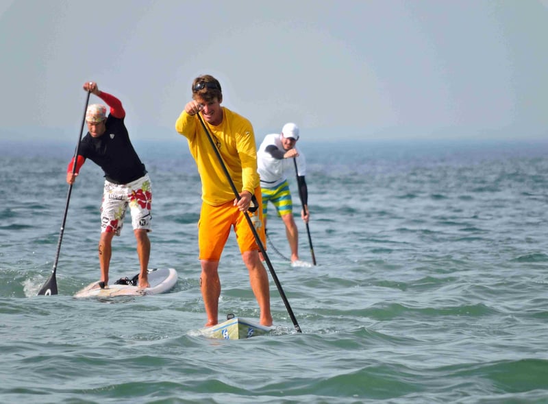 three men paddleboarding