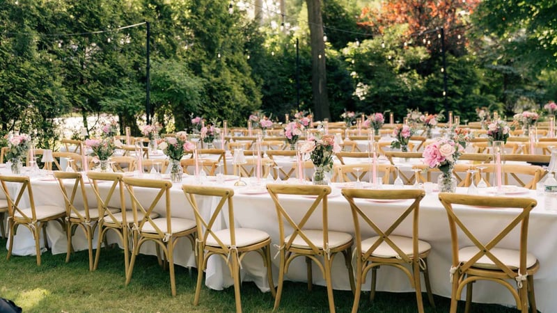 Charming outdoor wedding setup with elegantly decorated tables and chairs in a garden setting