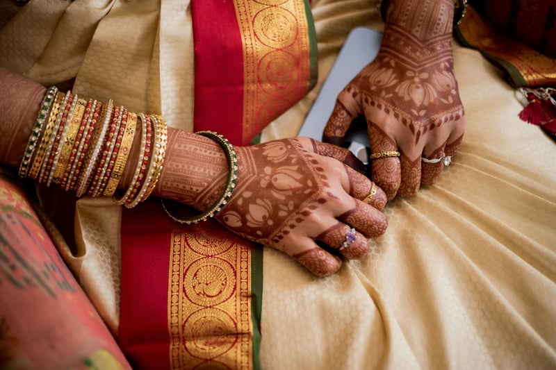 a close up of a Hindu bride's hands wearing many rings.