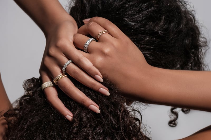 a model wearing multiple rings, including different engagement ring styles.