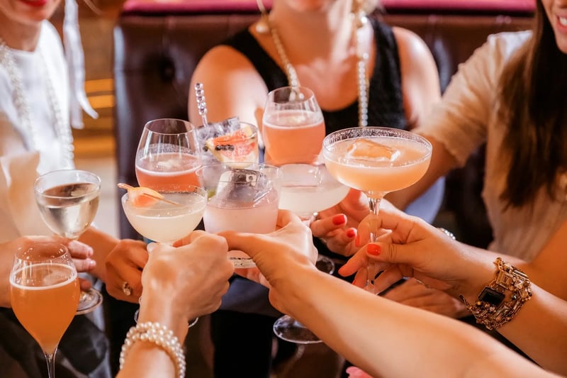 Frauen stoßen mit Cocktails an