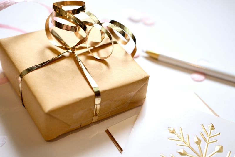 a present wrapped in gold paper and ribbon.
