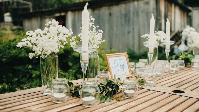 Charming outdoor table setting with candles and flowers for a rustic backyard wedding