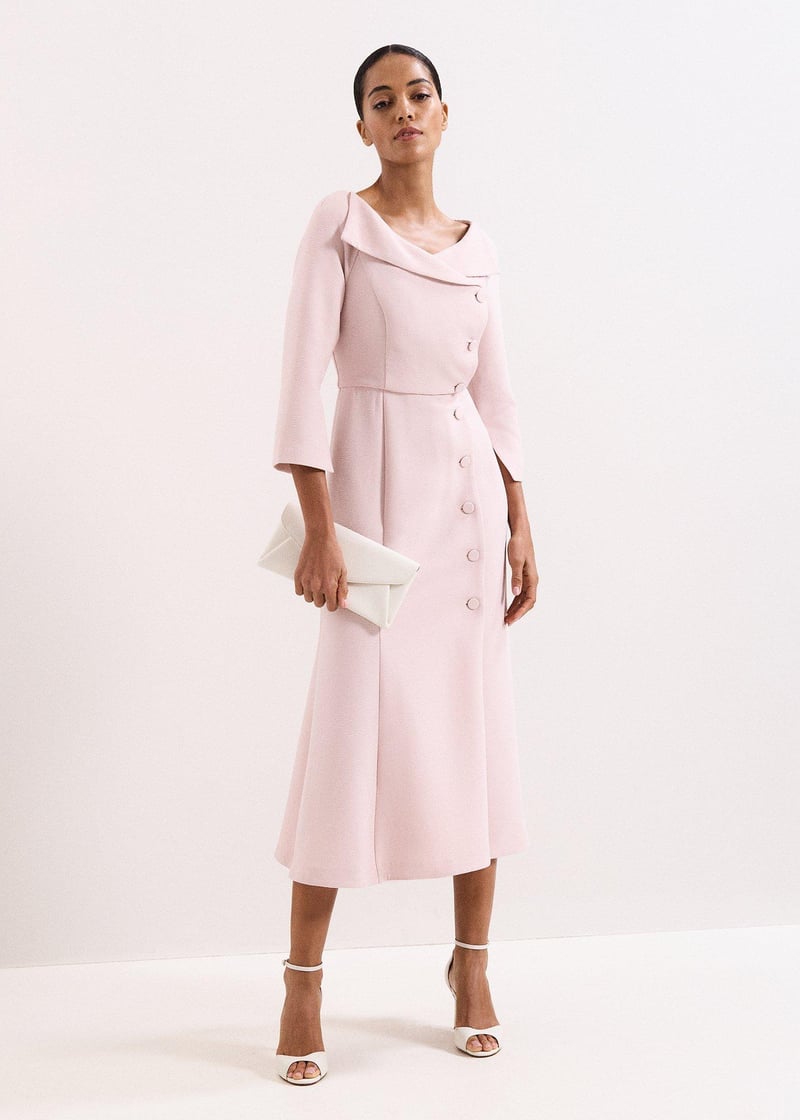 a model wears a pale pink tux mother of the bride midi dress with button down detail.