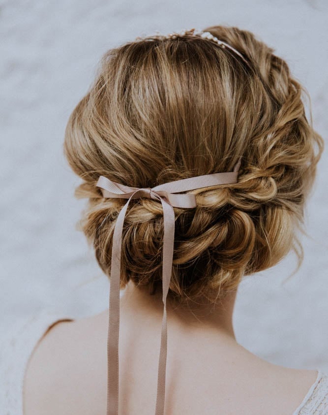 a bridal updo with a pleat at the front and a ribbon tied at the back.
