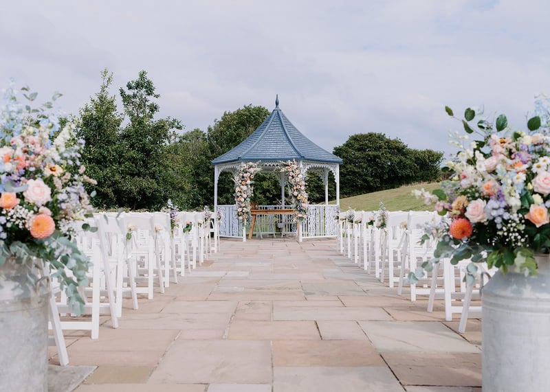 an outdoor wedding ceremony set-up with pergola.