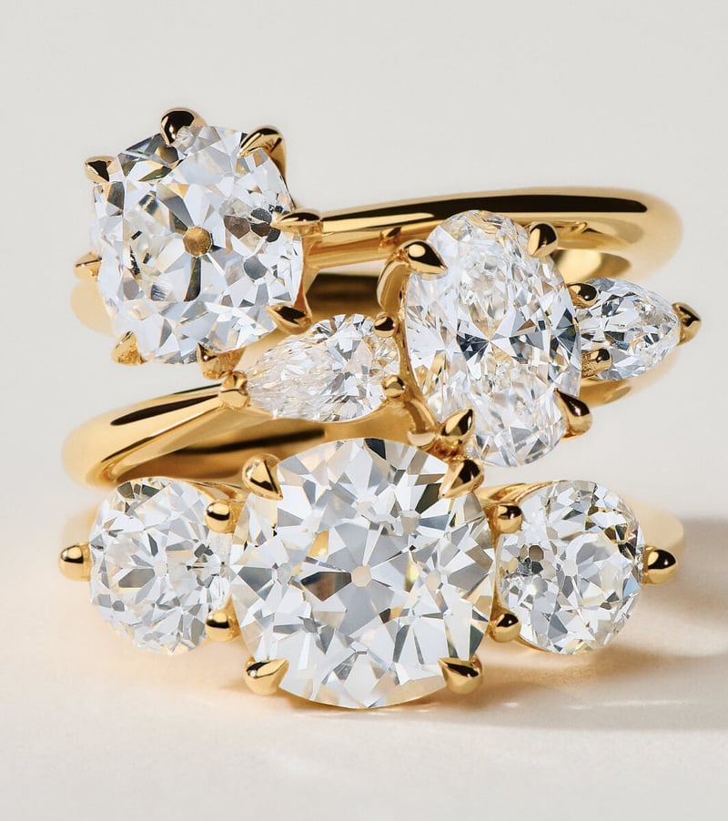 a stack of yellow gold and diamond cluster rings.