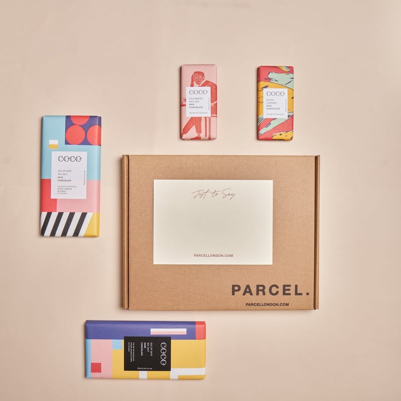 a brown box with handwritten notecard and miniature chocolate bars.