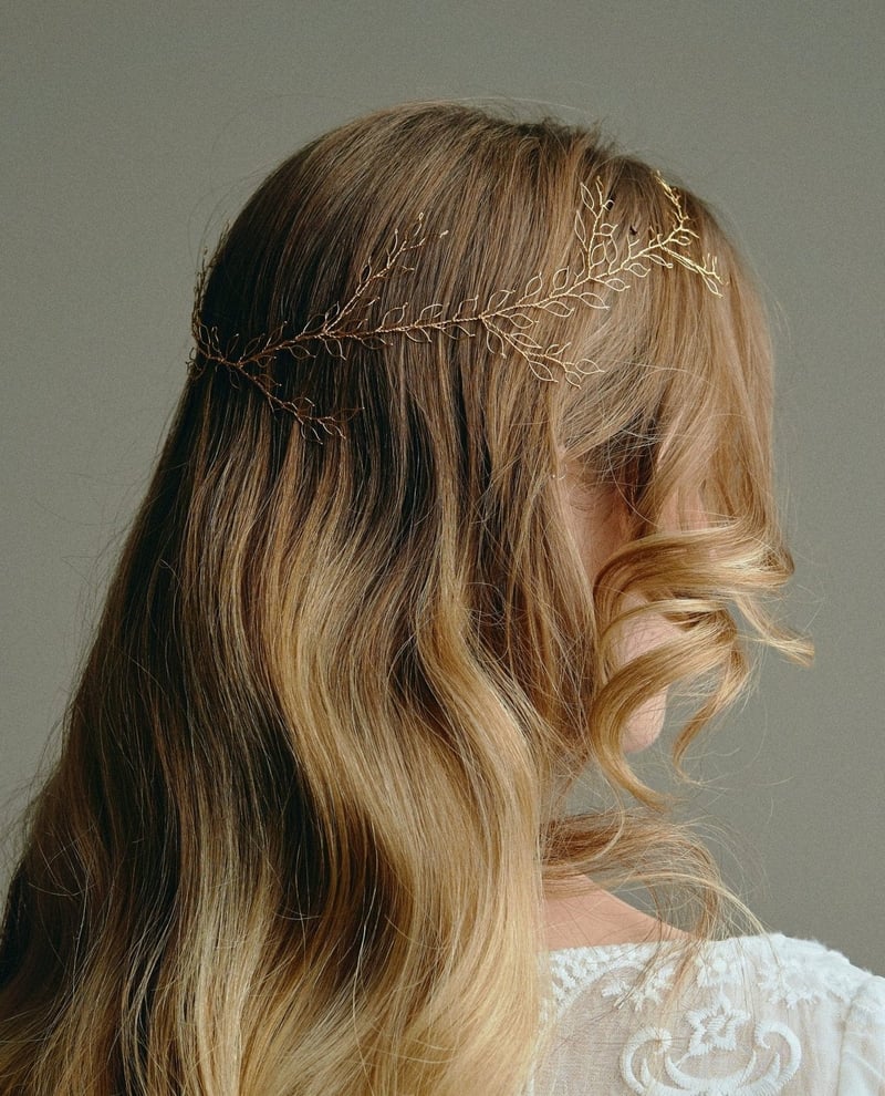 a model with mousy brown hair wearing a delicate gold hair vine.