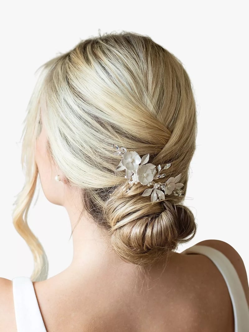 a blonde model wearing a wedding updo with a crystal plated floral hair clip.