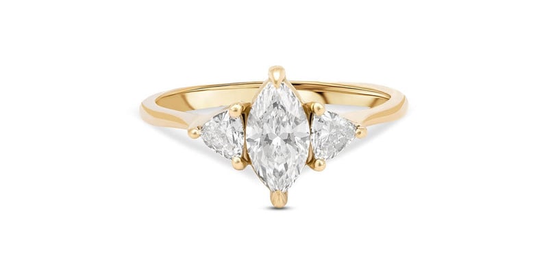 a yellow gold and marquise diamond three-stone engagement ring.