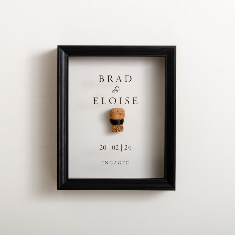 a personalised wall art featuring a cork in a black frame.
