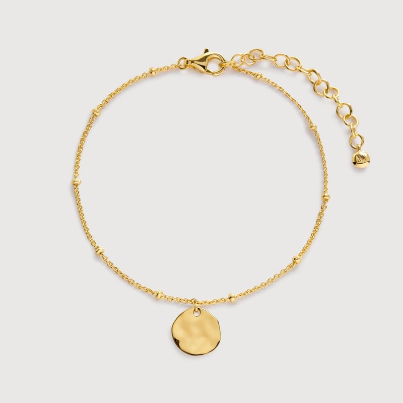 a gold disc bracelet. 
