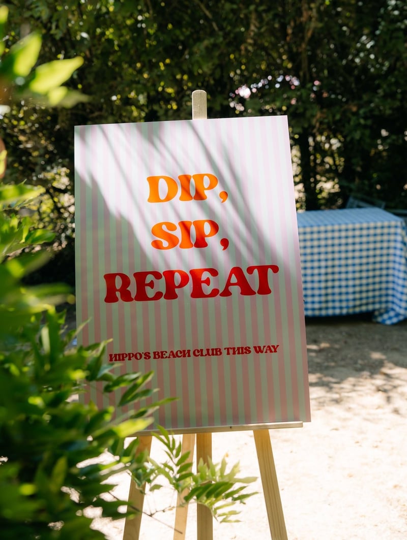 a pool party sign that reads, 'dip, sip, repeat' in a fun font.