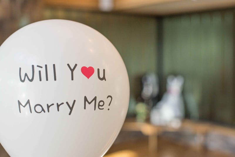 a white balloon that says 'will you marry me?'