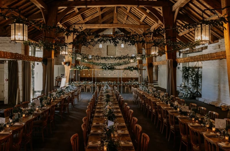 a wedding breakfast set up in the festive season with oak beams and fairy lights overhead