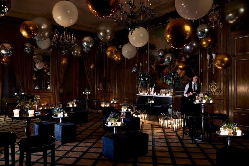 interior of a London wedding venue at Christmas with mood lighting, metallic baubles on the ceiling and a private bar.