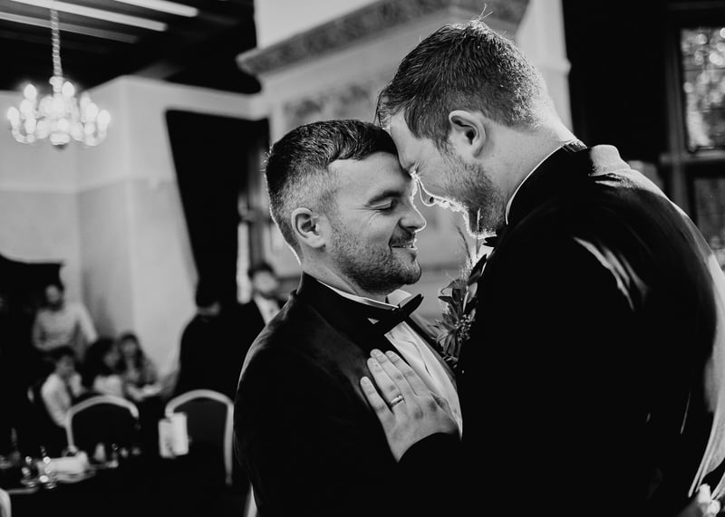 two grooms look happy as their dance together to a slow first dance song.