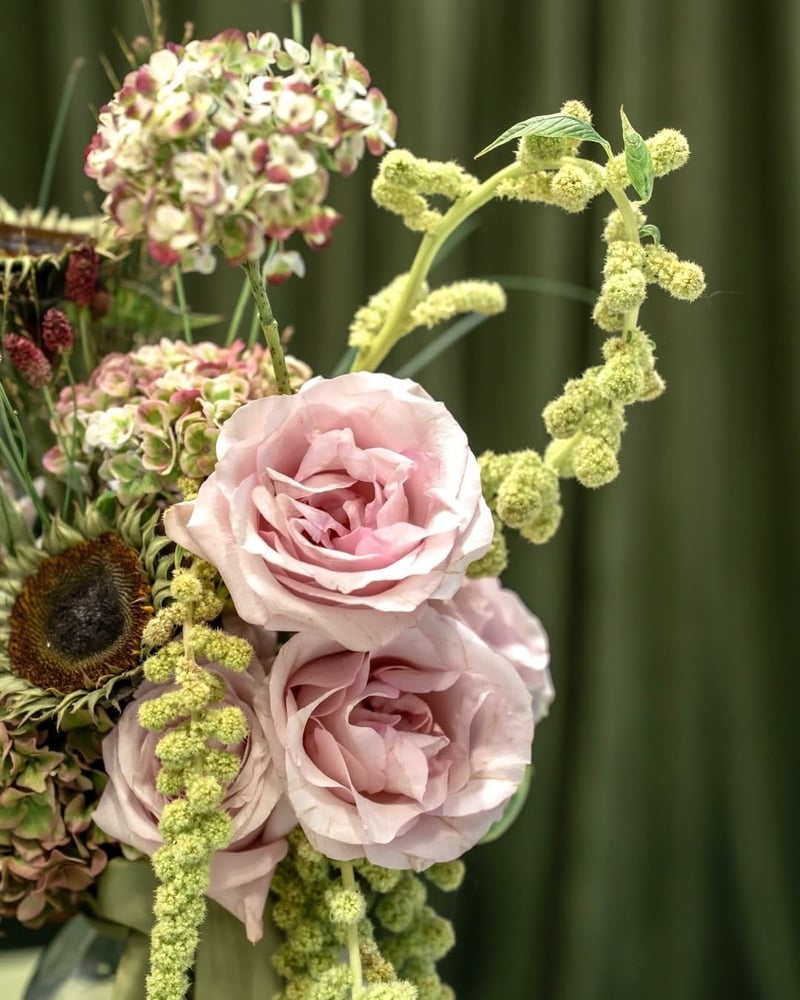 a floral installation featuring pink roses and agapanthus.
