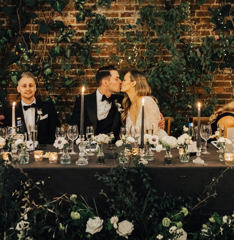 a bride and groom kiss at the top table of their Christmas wedding.