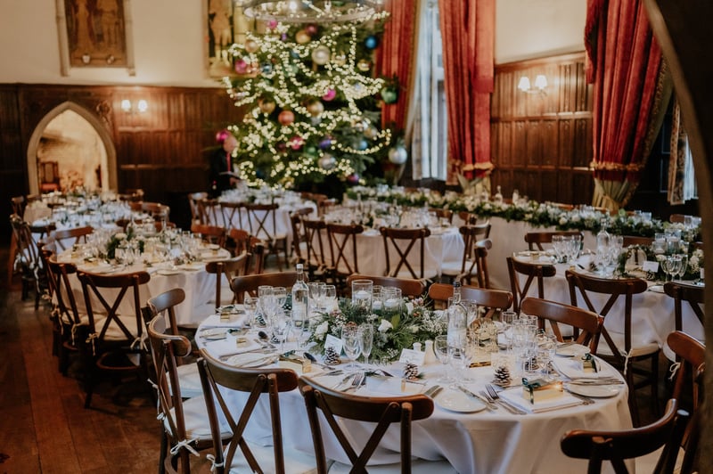 interior of a castle wedding venue at Christmas, with tables set up for a reception dinner.