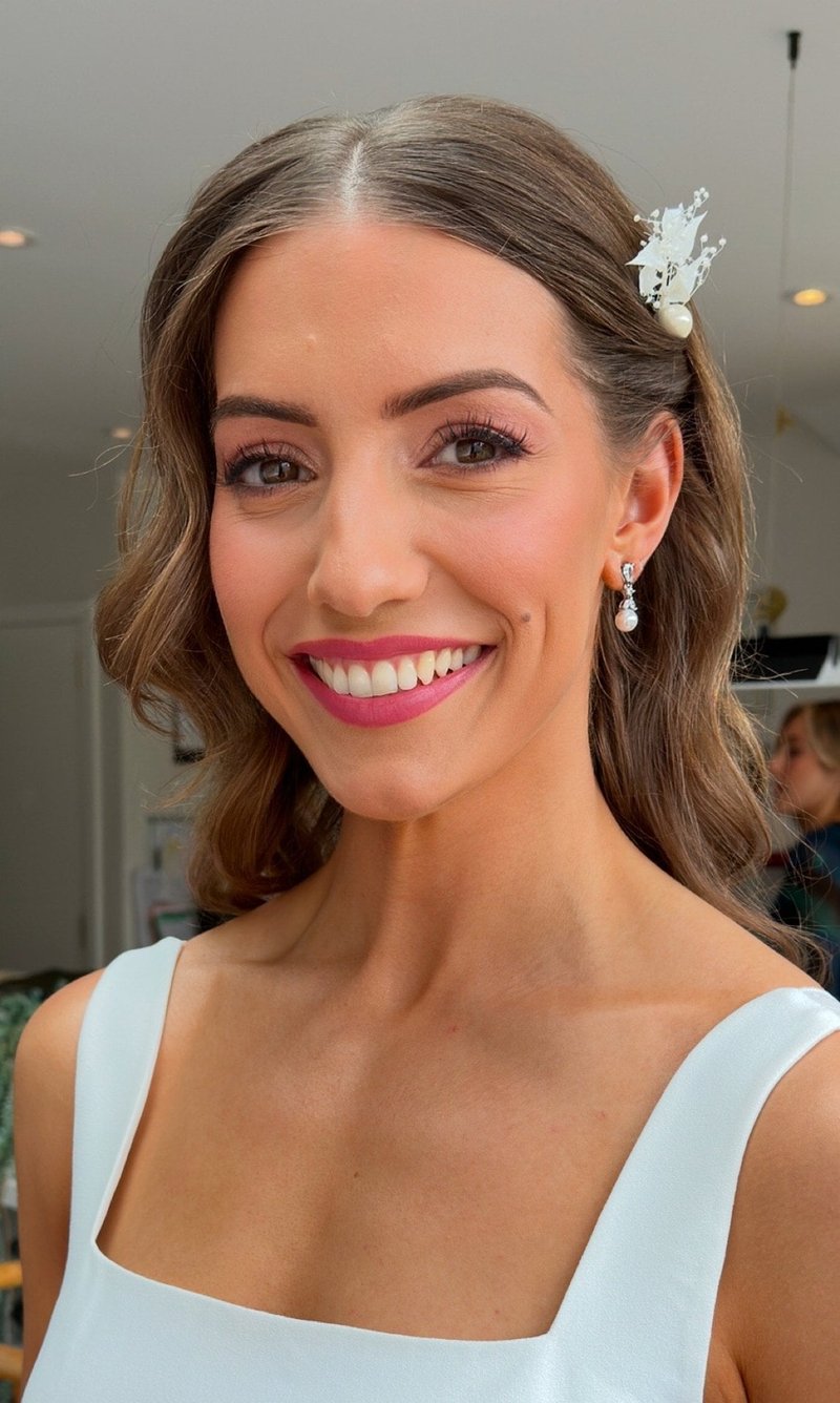 a bride with natural looking makeup smiles at the camera.
