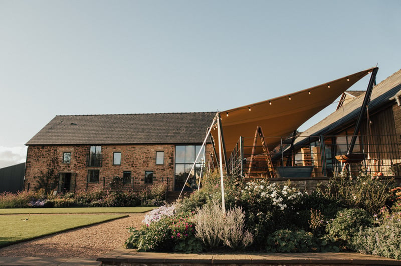 exterior of a modern barn venue with canopy.