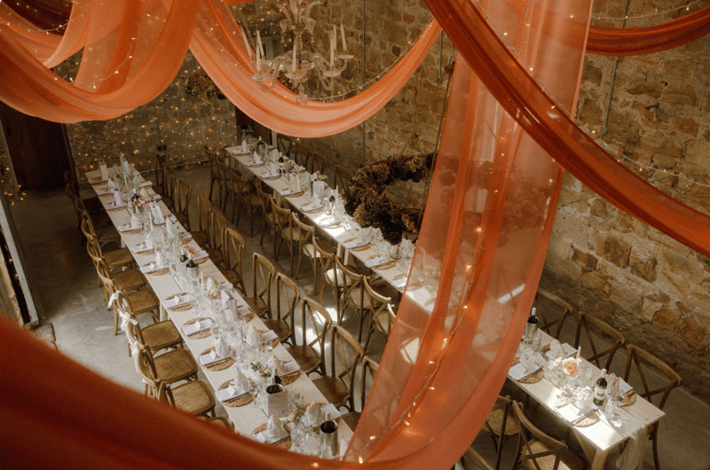 wedding breakfast set up with burnt orange drapery