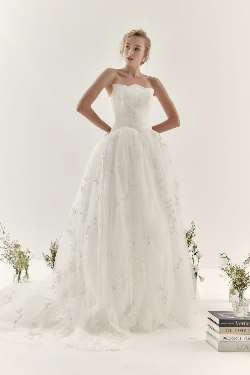 a model wears a romantic ballgown crafted from delicate hand-painted tulle.