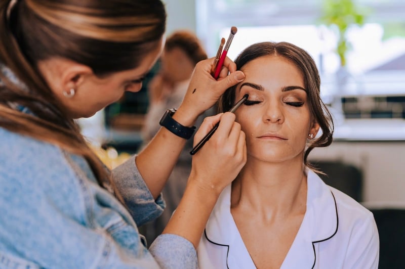 a bride gets her eye makeup applied by a wedding makeup artist.